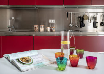 an elegant apartment in Veneto, with a kitchen in red and contrasting styles