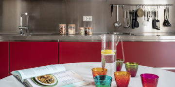 an elegant apartment in Veneto, with a kitchen in red and contrasting styles
