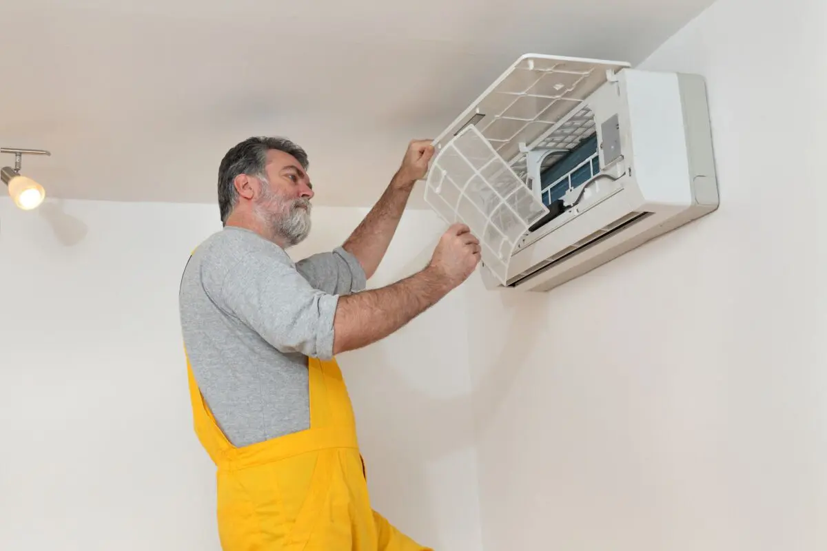 Electrician cleaning filter of air condition device in a room