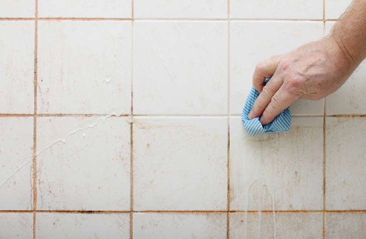 cleaning dirty shower and bathroom tiles with mold