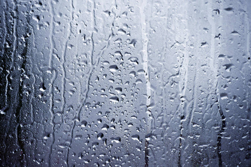 Rain water and condensation clings to window